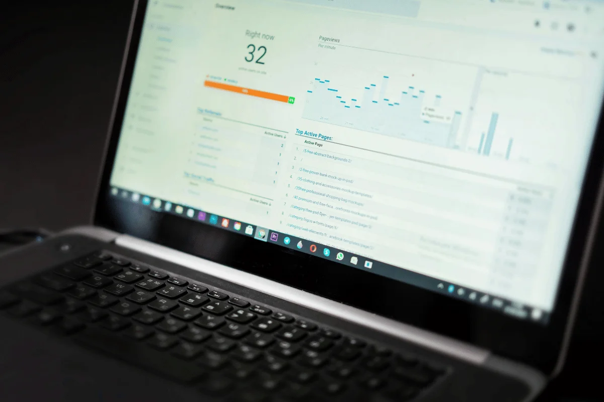 A laptop screen displaying Google Analytics with 32 active users.