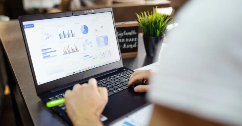 Professional analyzing churn rate analysis dashboard with blue charts and graphs on laptop screen in office workspace.