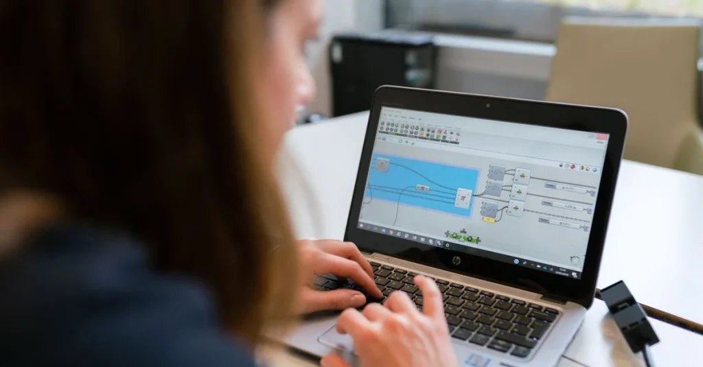 Person using laptop displaying sales analytics software dashboard with blue graphs and data visualization tools.